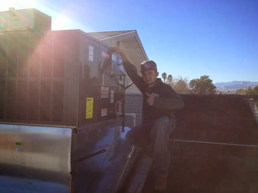HVAC technician performing AC Tune-Up on a rooftop unit in Gainesville